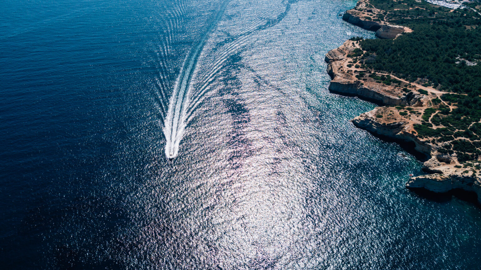 How to find the right boating courses: from basic skills to advanced training Speeding boat on the Atlantic Ocean with clear blue waters.